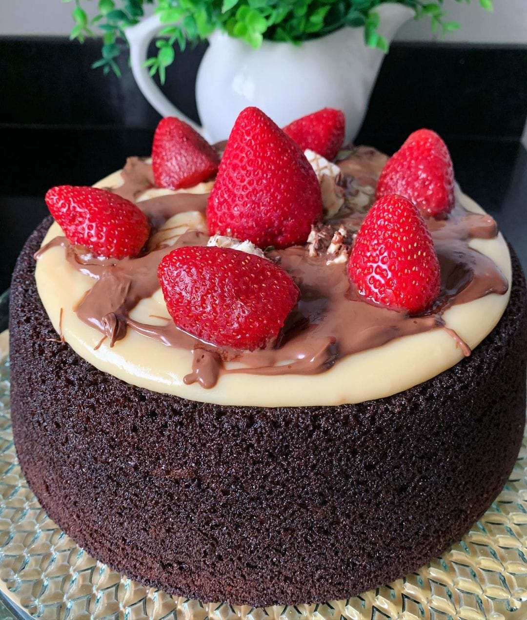 Bolo de chocolate com recheio de brigadeiro de ninho, com burela e morangos 